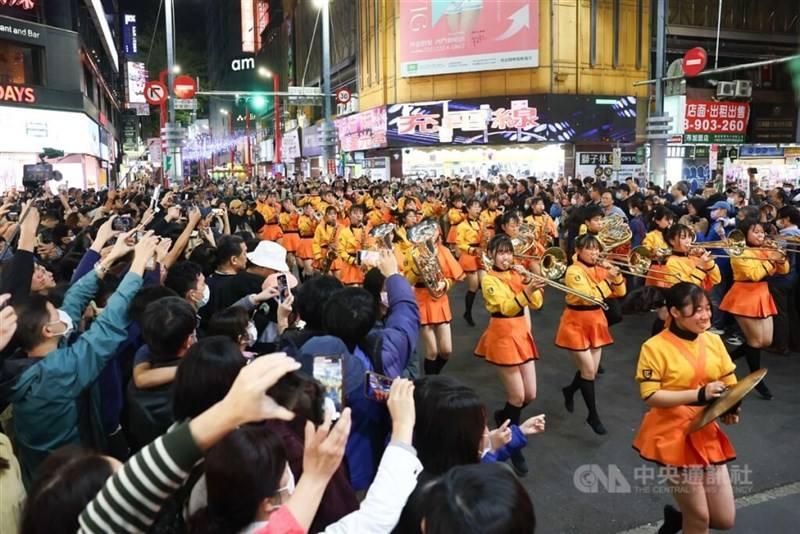 People crowd into a street at Taipei's Ximending shopping district Tuesday to watch the Orange Devils' performance. CNA photo Dec. 12, 2023