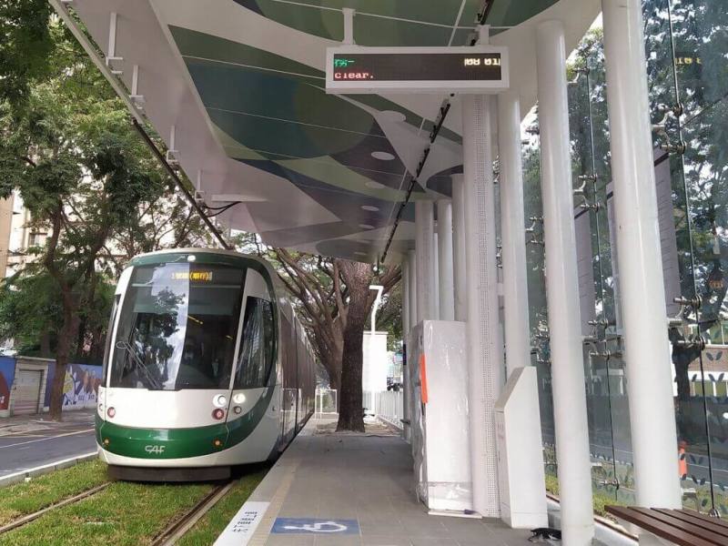 高雄輕軌即將成圓，預計2024年元旦後全線通車試營運。C24站至C29站間，共種有318棵雨豆樹，並取名為「綠巨人隧道」。（高雄市捷運局提供）