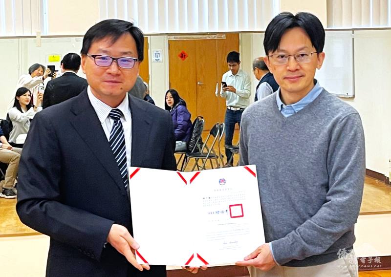 潘昭榮 (左)代表僑委會送上賀狀，恭喜麻州大學教授游子揚接任中華專協董事長