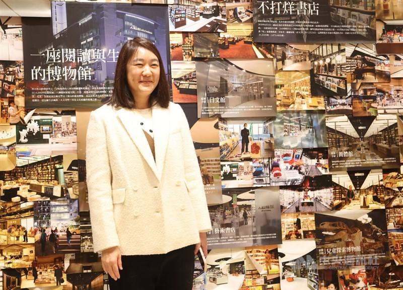 The chair of Eslite Spectrum Corp. Mercy Wu (吳旻潔) pose with the memorial wall of Eslite's 24-hour bookstore in Taipei's Xinyi district on Sunday.