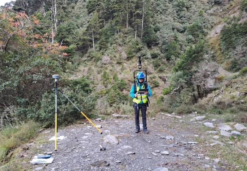 農業部林業及自然保育署南投分署29日表示，南投縣信義鄉郡大林道全線約33公里，為提升林道監測精度和管理，推動林地環境3D智慧管理，民眾可透過Google Map街景服務看到林道高解析度影像，提高登山活動安全。圖為工作人員背負環景設備拍攝郡大林道。（林業及自然保育署南投分署提供）