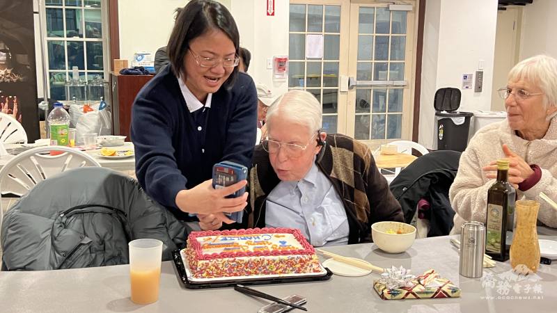 吳明真用手機影像蠟燭邀請壽星吹蠟燭，切蛋糕慶生