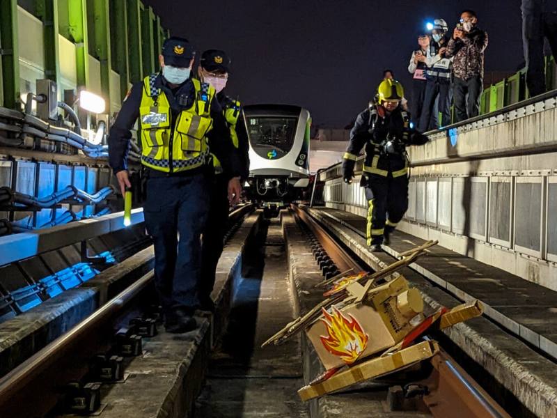 台中捷運公司6日凌晨在捷運綠線松竹站進行多重災害模擬演練，模擬異物掉落軌道及發生火災等狀況，消防局北屯分隊撲滅火勢後，警察局捷運警察隊會同消防人員進入軌道區巡檢，並針對火災原因進行調查。（中捷公司提供）