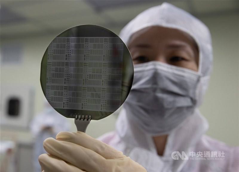 An engineer holds a semiconductor