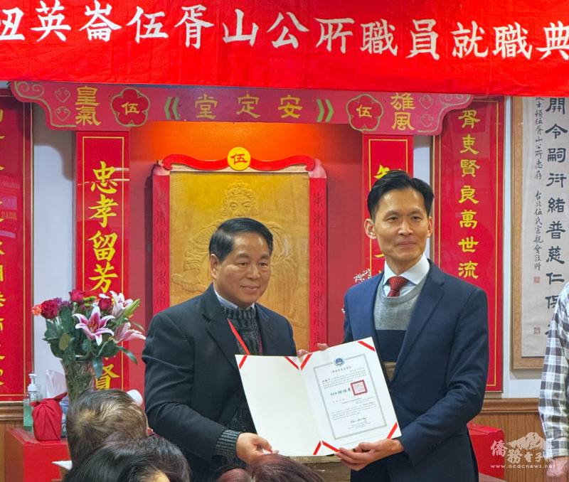 駐波士頓辦事處處長廖朝宏(右)頒發賀狀給新任伍氏主席伍振中(左)