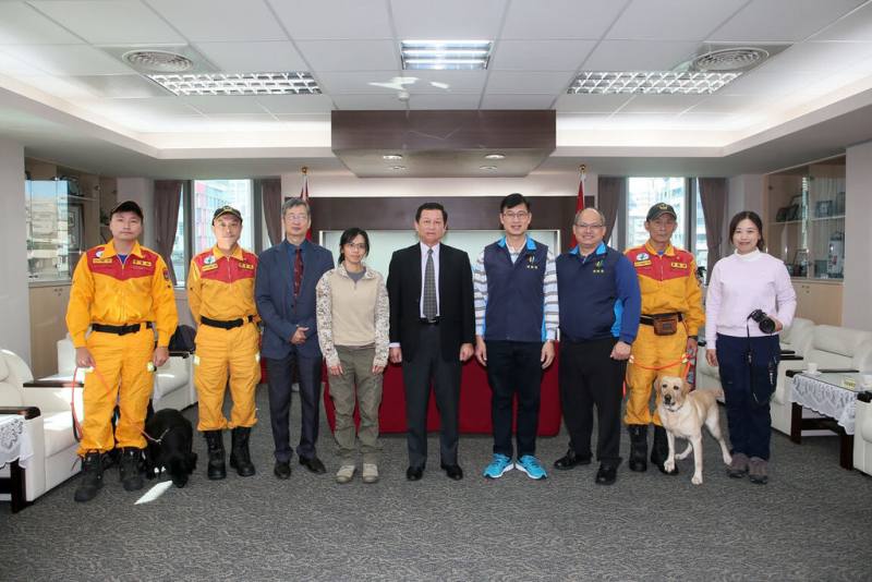 台北市消防局長莫懷祖（左5）17日和台灣偵搜犬協會理事長洪菡擎（左4）共同簽署合作備忘錄，透過公私力合作機制，盼強化北市搜救犬救援能量。（台北市消防局提供）