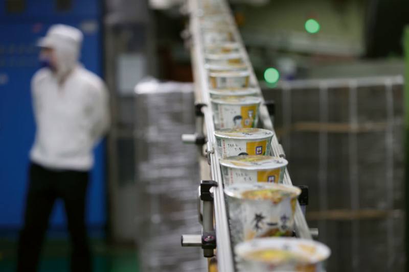 Production of instant noodles in the factory of Uni-President Enterprises is entirely automated, but there are many workers on site for quality assurance.