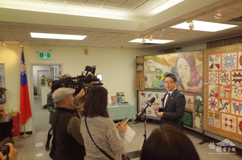 藍柏青接受多倫多華文媒體採訪，背後為民俗文化種子教師成果聯展的作品