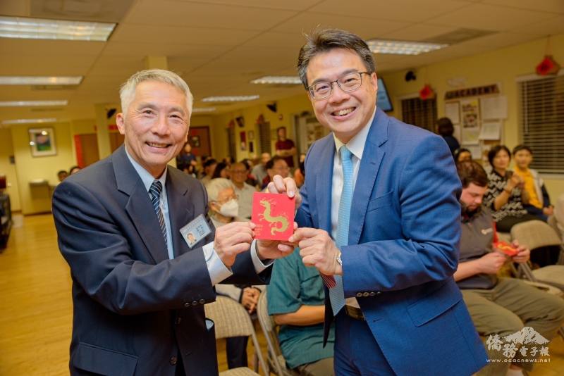 駐邁阿密辦事處處長周啟宇(右)致贈總統府龍年福袋予邁阿密慈濟負責人林明哲(左)