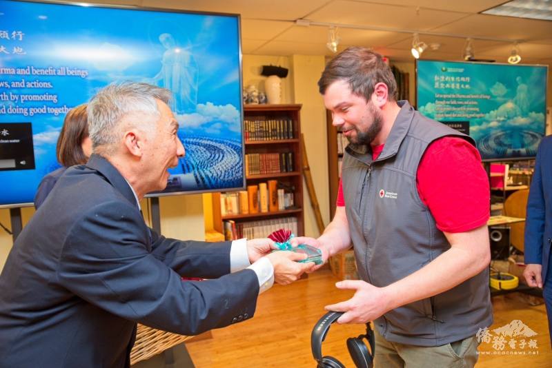 林明哲(左)致贈福慧紅包予紅十字會代表Zack Stokes(右)