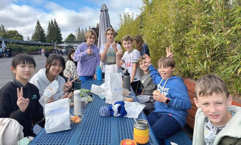 新北市桃子腳國中小師生寒假期間與美國姊妹校矽谷國際學校交流，學生進入班級共學與伴讀2週，桃子腳學生和美國學伴圍成一圈，享用自己訂的午餐。（桃子腳國中小提供）