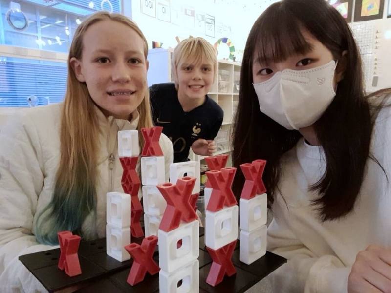 新北市桃子腳國中小近日與美國姊妹校矽谷國際學校展開交流，7年級學生陳品萱（右）體驗美國學校生活，與美國學伴一起玩桌遊。（桃子腳國中小提供）