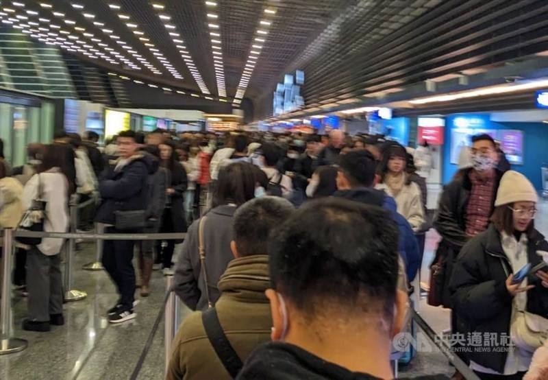 Passengers wait in long lines in Taiwan Taoyuan International Airport's Terminal 1 for security checks in mid-January 2024.