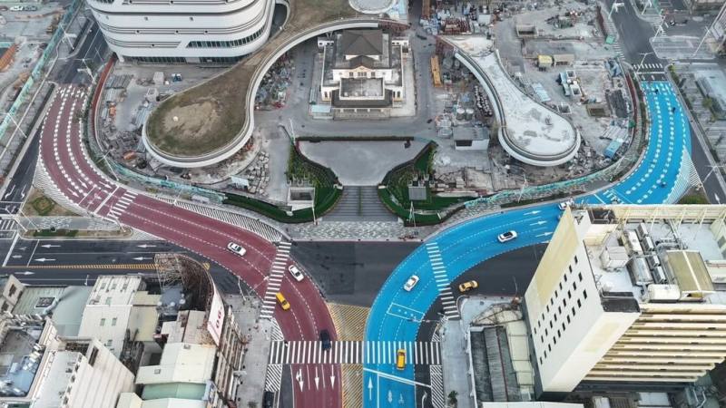 高雄車站前的站西路路面彩色鋪面4日清晨完工，選用防滑係數較高的骨材標線並添加色料進行車道塗繪，往北的站東路為藍色、往南的站西路為紅磚色，以強化車道辨識度（高雄市工務局提供）