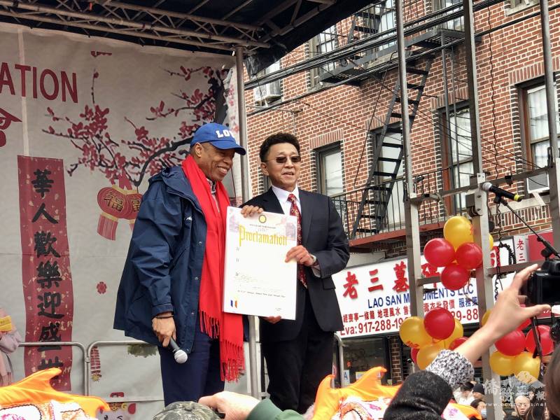 紐約市市長亞當斯(Eric Adams)(左)讚揚布祿崙華人協會成立35年來連續舉辦新春慶祝活動和為社區做出的貢獻，同時頒發表揚狀給會長麥保羅(右)