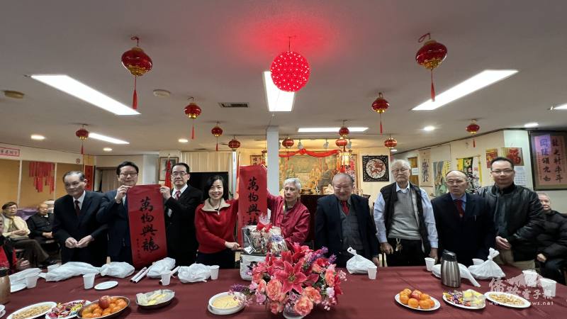 駐多倫多辦事處處長陳錦玲(左四)與多倫多龍岡親義公所主席張雅才(右五)、副處長洪松暉(左三)與多倫多文教中心主任藍柏青(左二)致贈總統春聯，於2月11日大年初二向多倫多龍岡親義公所鄉親拜年