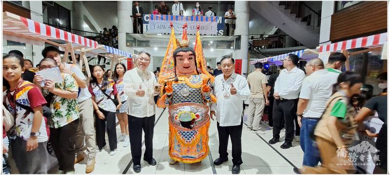 「臺灣體驗日」迷你市集請出電音三太子出場助陣，駐菲律賓代表處公使楊登仕（左）及宿霧文藝中心常務委員鄭宗傑僑務委員（右）歡喜合影