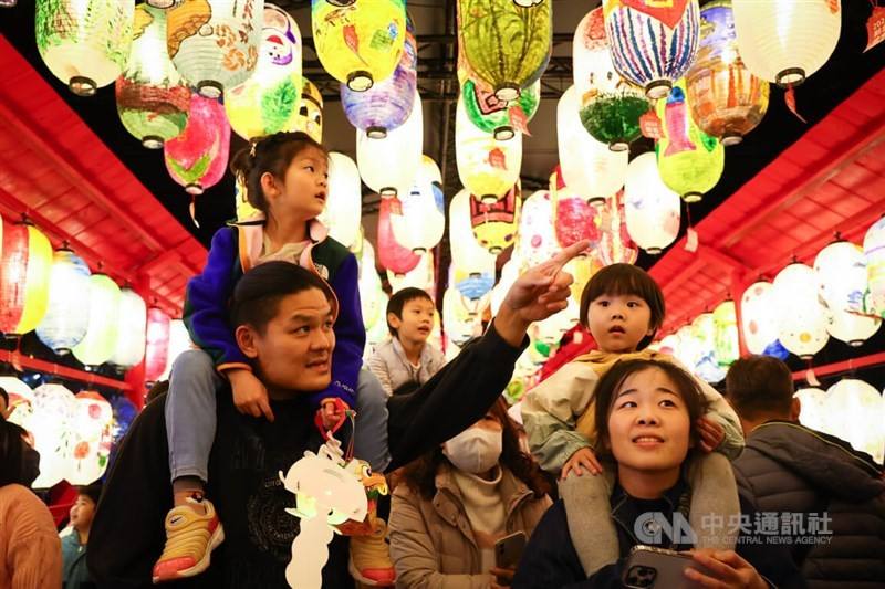 A family takes a stroll through the lantern display of the New Taipei Lantern Festival on Saturday night. CNA photo