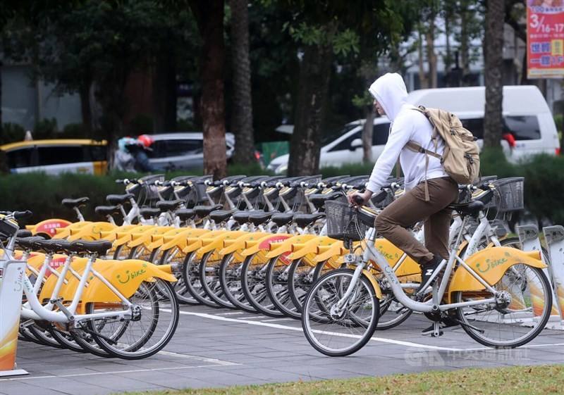 A commuter rides his YouBike by a parking station in Taipei on Tuesday. CNA photo