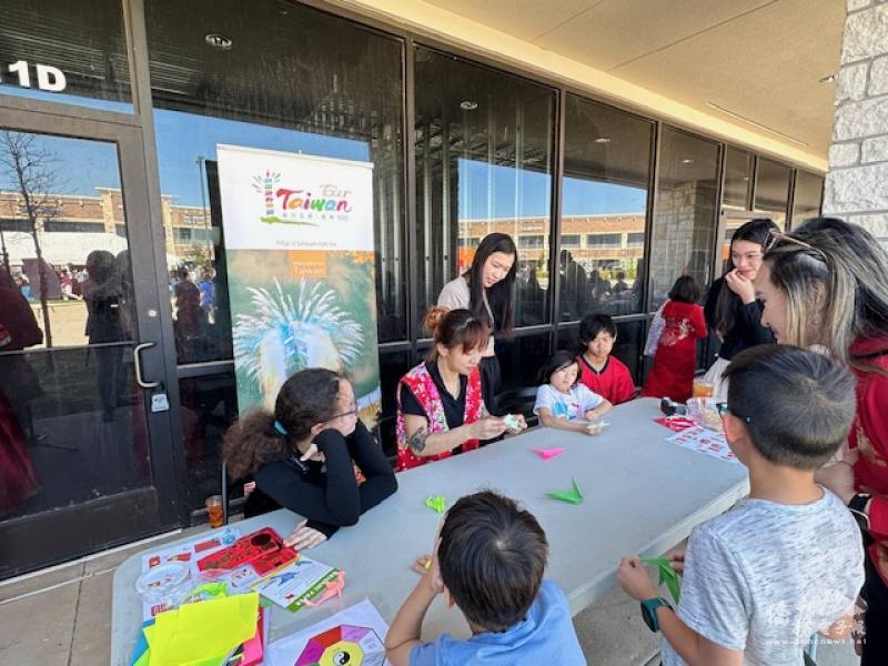 穿著客家花布背心的戴曉芸藉展演摺紙過程解說臺灣特色摺紙的意涵