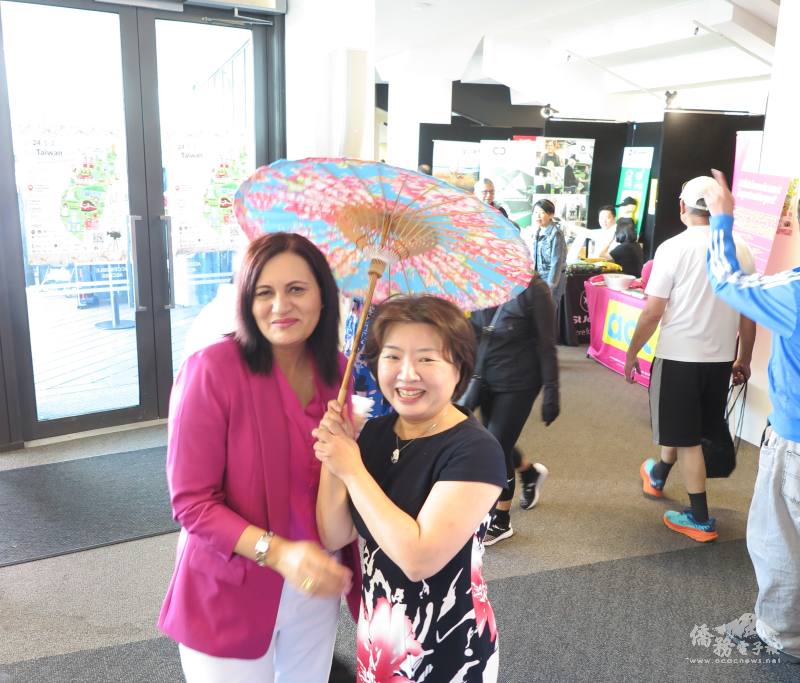 聯合執政黨行動黨國會議員Dr. Parmjeet Parmar（左）與駐奧克蘭辦事處處長陳詠韶（右）手持客家花布傘合影