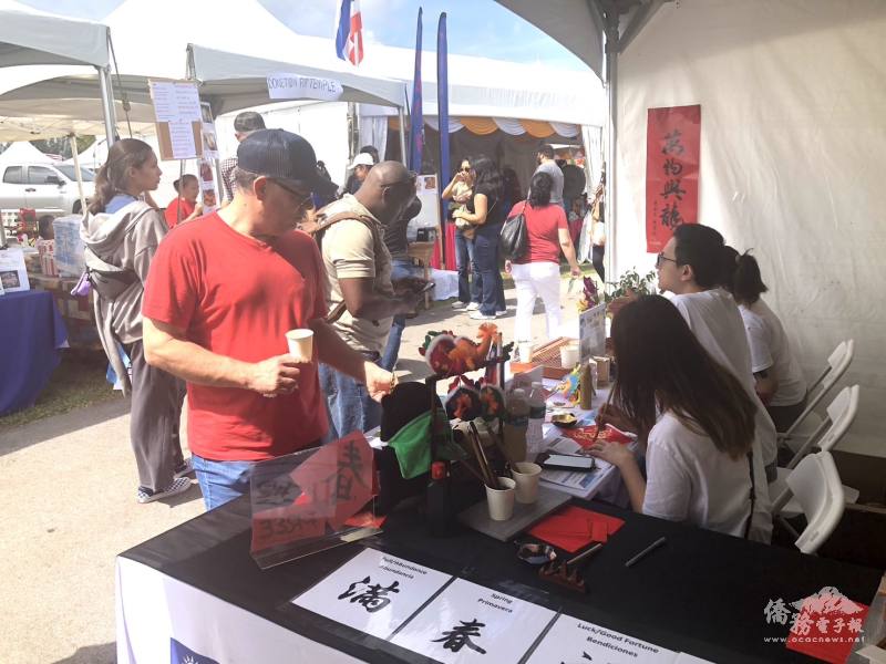 民眾在辦事處展攤前排隊索取現場揮毫的書法字帖