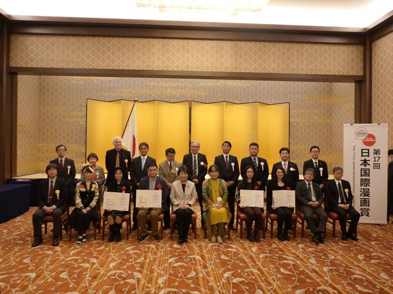 由日本外務省舉辦的第17屆日本國際漫畫賞5日晚間在東京舉頒獎典禮，台灣漫畫家簡嘉誠（前排左4）以作品「青空下的追風少年」獲最優秀獎（金獎），日本外務大臣上川陽子（前排左5）坐在他身旁。