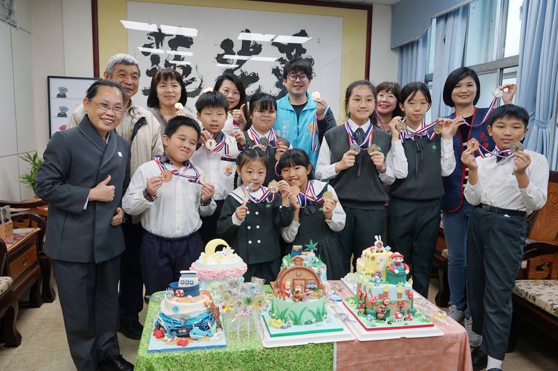 花蓮烘焙師黃湘涵率領一群年齡5歲至13歲的小小子弟兵出征德國國際觀光烹飪大賽，在翻糖蛋糕、星空棒棒糖等項目囊括19面獎牌，6日下午與花蓮市長魏嘉彥（藍色背心者）等人分享喜悅。