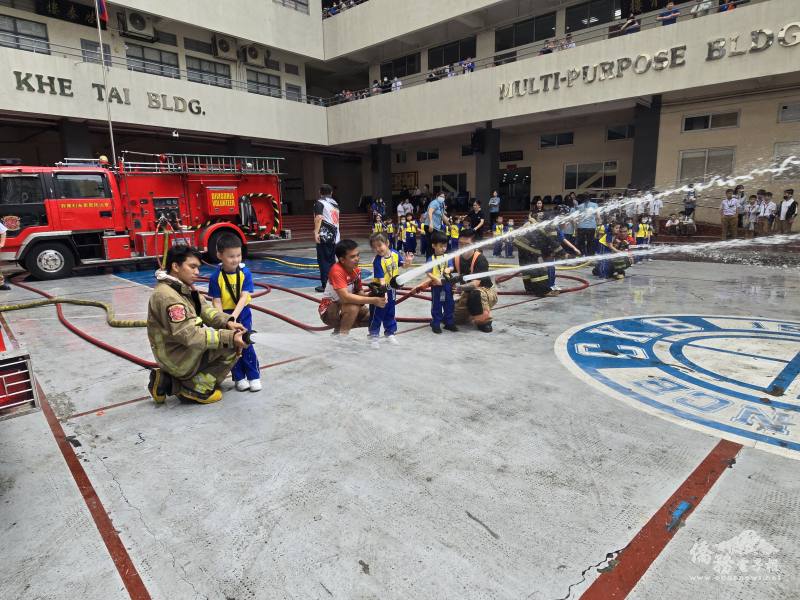 泉笙培幼園學生在打火兄弟的協助下體驗使用瞄子射水