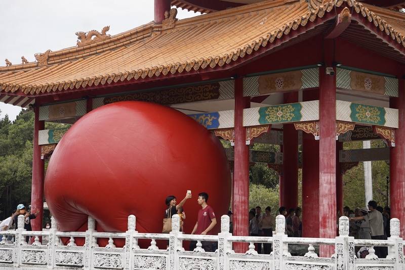 紅球台南歷史街區策展行動31日移展台南公園念慈亭，充氣後在南側臨湖處亮相，吸引許多旅客湧入，拍照留念。