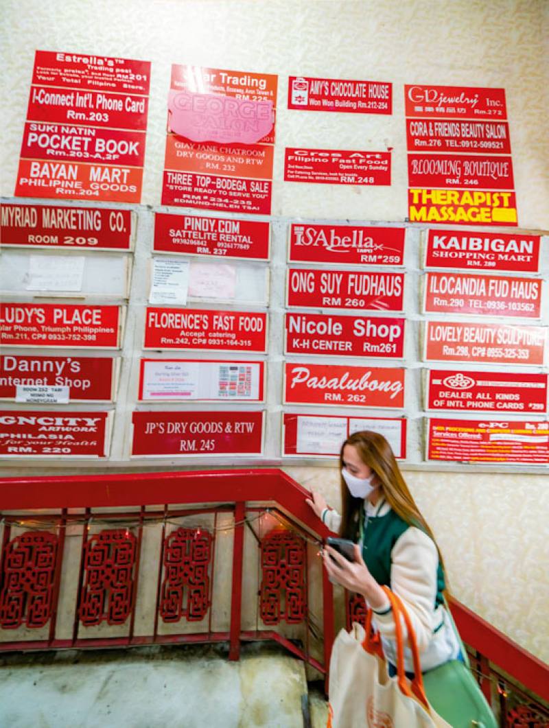 Signs on the wall show the names of the shops inside the King Wan Wan Shop Mall. Filipinos decide which ones to patronize based on recommendations from their social networks.
