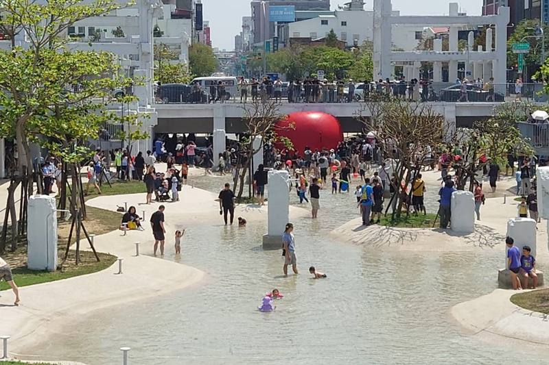 紅球台南歷史街區策展行動4日移展河樂廣場，巨大紅球出現在廣場中央接近金華路下方親水區，民眾可一邊玩水一邊與紅球互動拍照。