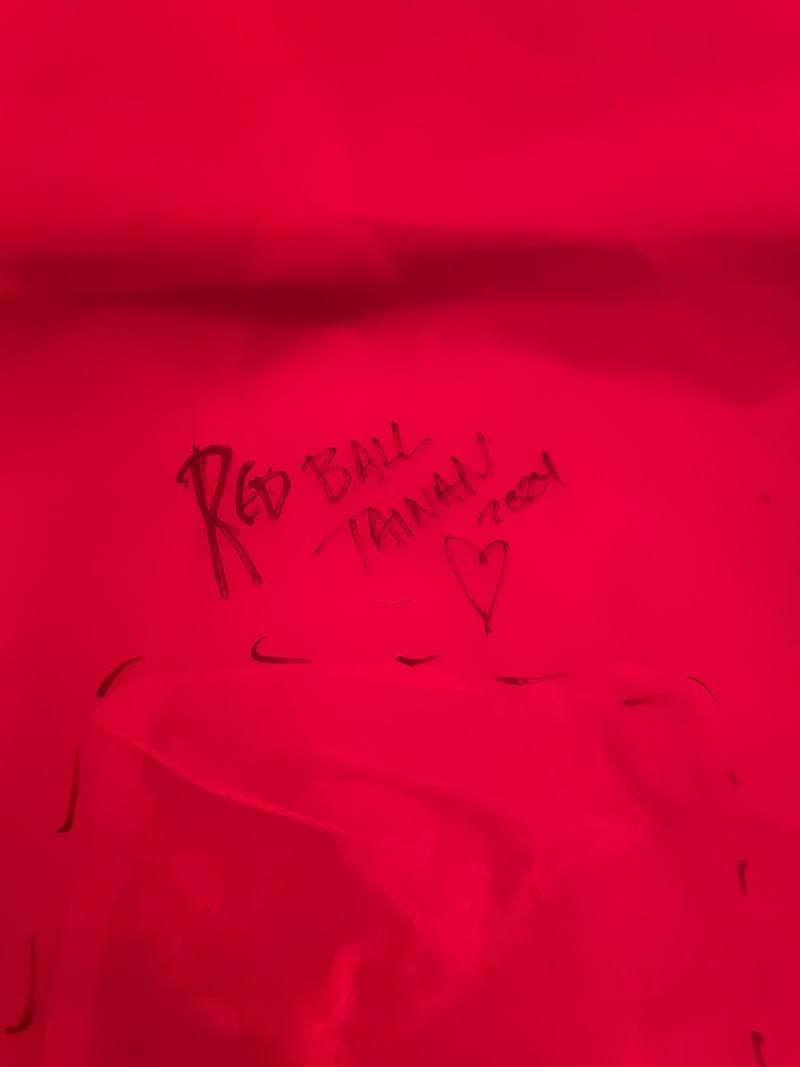 紅球台南歷史街區策展行動5日移展歷史建築「原新化街役場」，上午充氣過程紅球一度遭鷹架刺破，藝術家波希克（Kurt Perschke）緊急修復，並在修補處寫下REDBALL TAINAN 2024字樣。（台南市文化局提供）