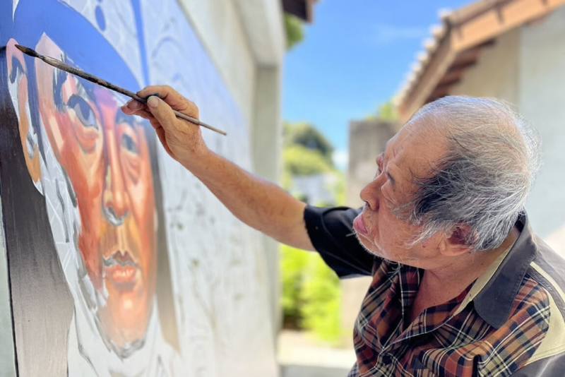 台南市文化局於水交社文化園區工藝聚落戶外區域舉辦「顏振發–水交社手繪看板特展」，部分作品並由國寶級手繪電影看板畫師顏振發（圖）現地繪製。（台南市文化局提供）