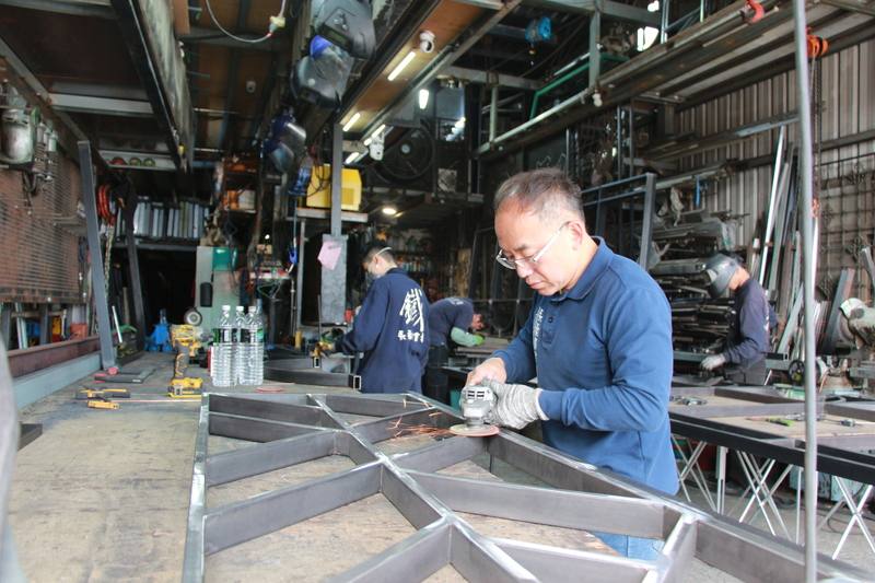 儘管鐵花窗在新式建築已不再流行，永燊達金屬業者曾文昌（前）仍堅守傳統技藝，甚至將鐵花窗結合文化創意，希望讓傳統技藝持續流傳。