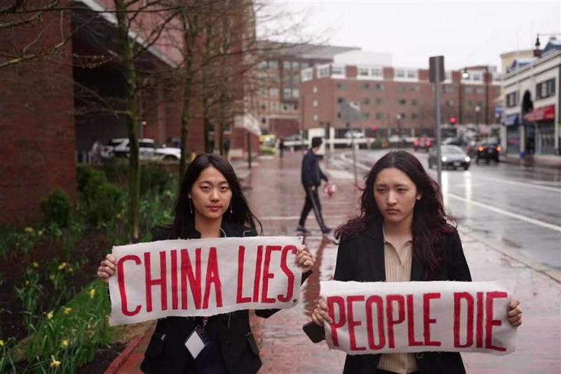 Taiwanese-American Cosette Wu (left) and Tibetan-American Tsering Yangchen (right) members of Harvard University's Coalition of Students Resisting the CCP, hold banners that together read "China Lies, People Die" to protest Chinese Ambassador to the Unite