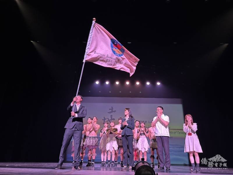 陳柏琴(前排左2)授旗予「2024年美國臺灣傳統週暨加拿大亞裔傳統月」美加西團團長-福爾摩沙馬戲團 (前排左)，預祝訪演順利成功。