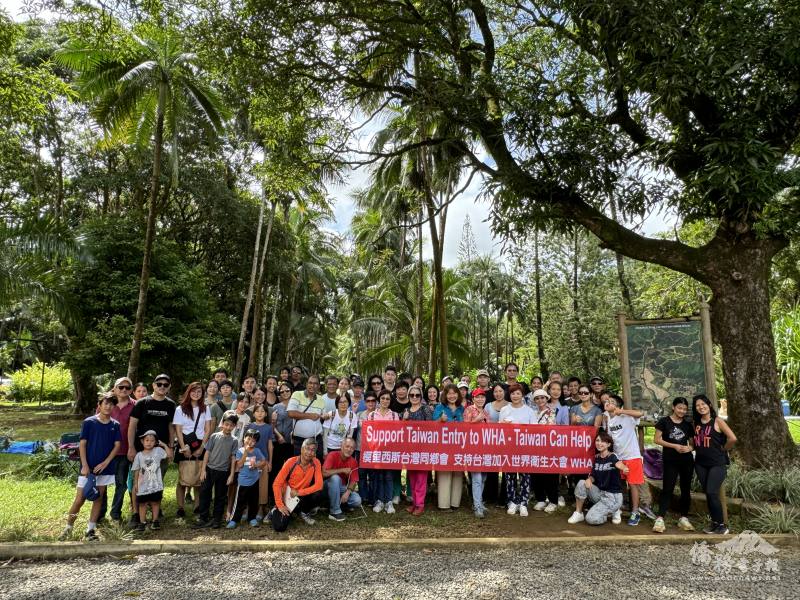 活動參與者於健行後在熱門觀光景點前合照，吸引眾多觀光客目光