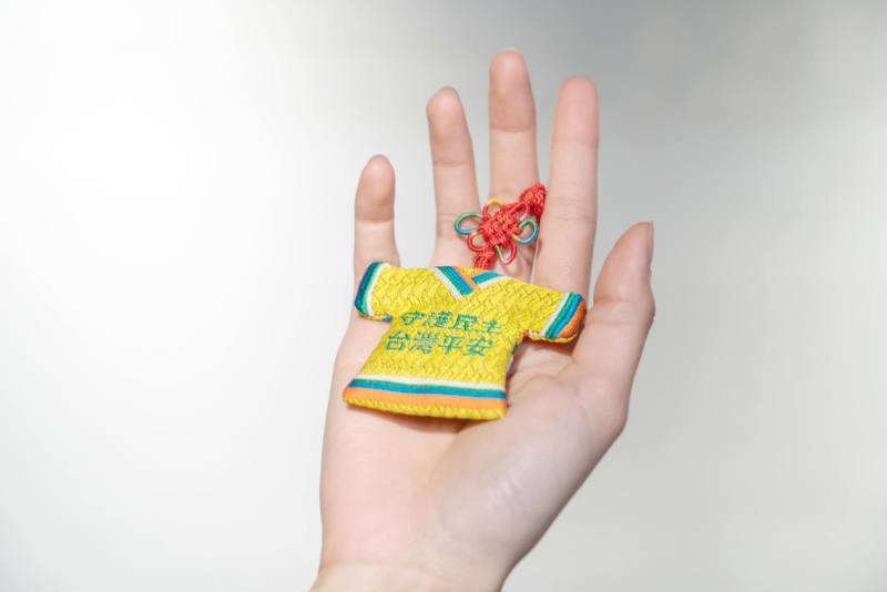 印有「守護民主、臺灣平安」的小神衣造型平安符，保佑僑胞平平安安 (圖片來源：中華文化總會臉書)