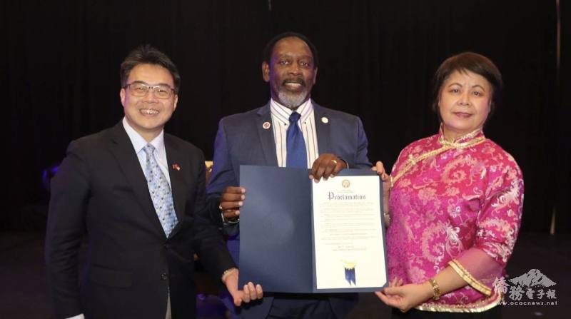 橘郡郡長Demings(中)頒贈賀狀肯定大奧蘭多臺商會的貢獻，由周啟宇(左)、會長梁桂台(右)代表接受
