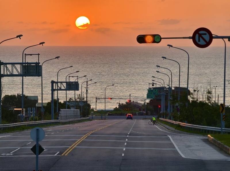 苗栗縣通霄「日落大道」因太陽移動軌跡之故，夕陽由道路正中央沉入海中的最美時刻即將到來，在地攝影工作者張文煥15日指出，預估本週末將是最佳觀賞時機。（張文煥提供）