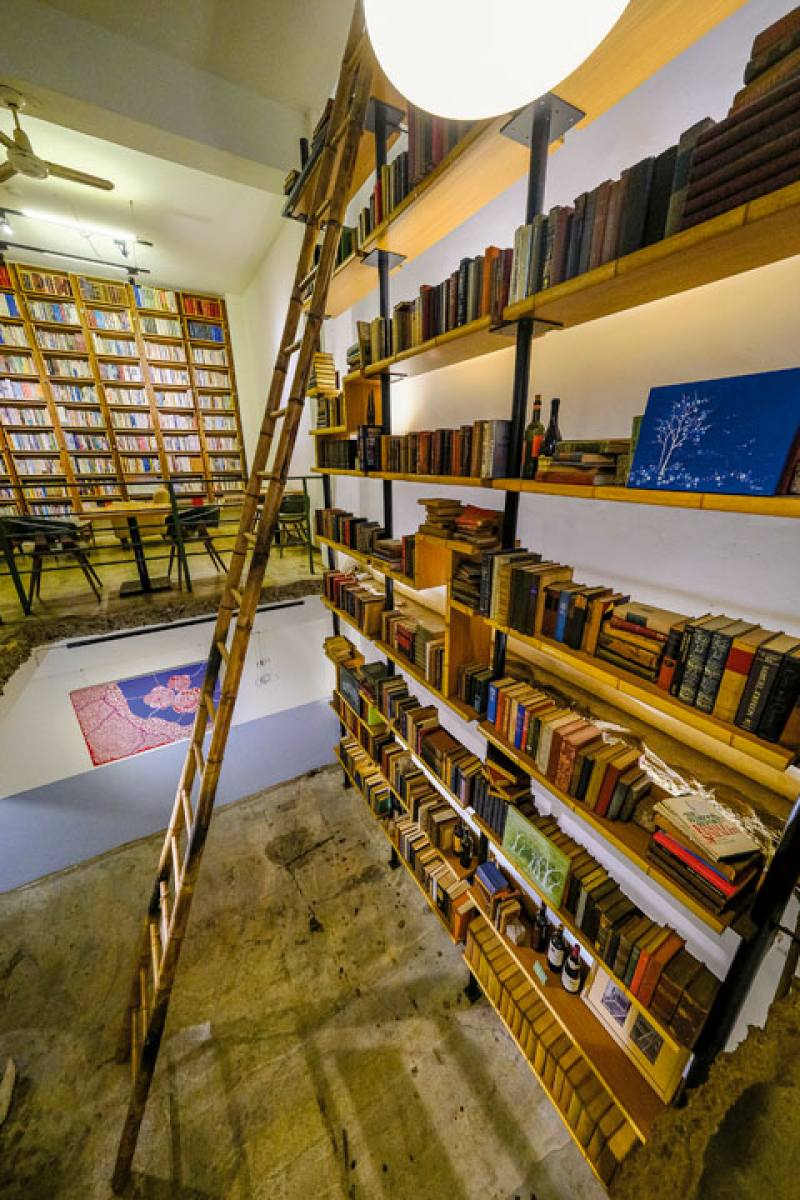Bookshelves extending from the basement to the first floor, a grid of criss-crossing rebars, and a cozy but not claustrophobic arts space are all features of CaoJi Book Inn that already existed when the place was a bookshop.​​
