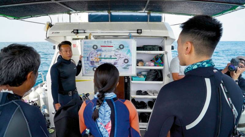 Undersea filming in moving waters is challenging, and divers must be able to reliably respond to changing conditions. The photo shows a pre-dive briefing with the production team.​​ (photos by PTS Shipwrecks Taiwan)