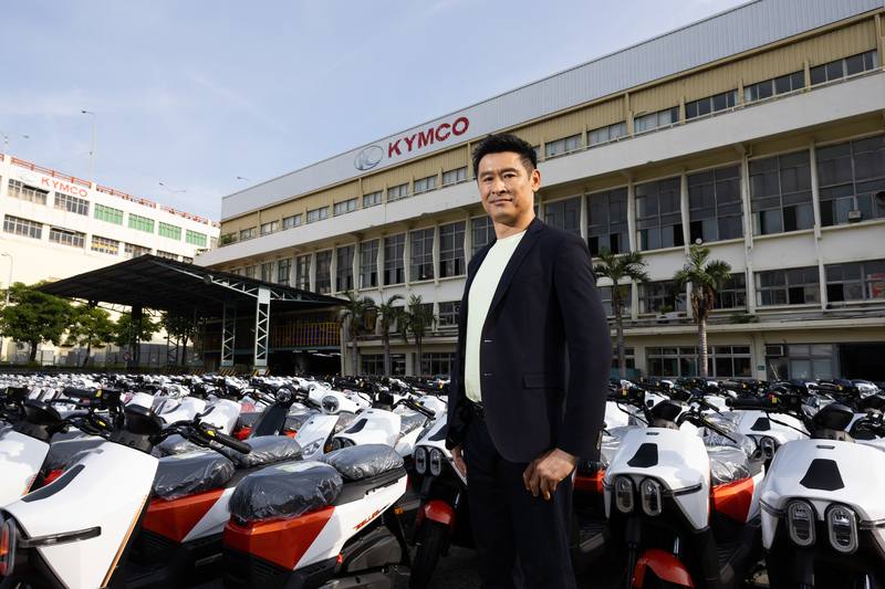 光陽集團董事長柯勝峯希望，光陽是受消費者認可，具備全球品牌形象與價值的企業。圖為柯勝峯在高雄廠區，後方為即將出廠交運給經銷商的車輛。