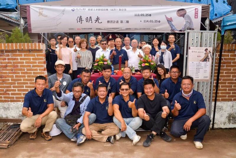 文化部文資局與新竹縣文化局合辦「重要土水修造技術－傅明光保存者傳習計畫」，113年續辦第2期；邀請「客家建築活教科書」傅明光傳授「燕尾脊祕笈」，不少年輕匠師前來學習。圖為文資局主任祕書張祐創（3排左3）、傅明光（3排左4）與學員合影。（文化部文資局提供）
