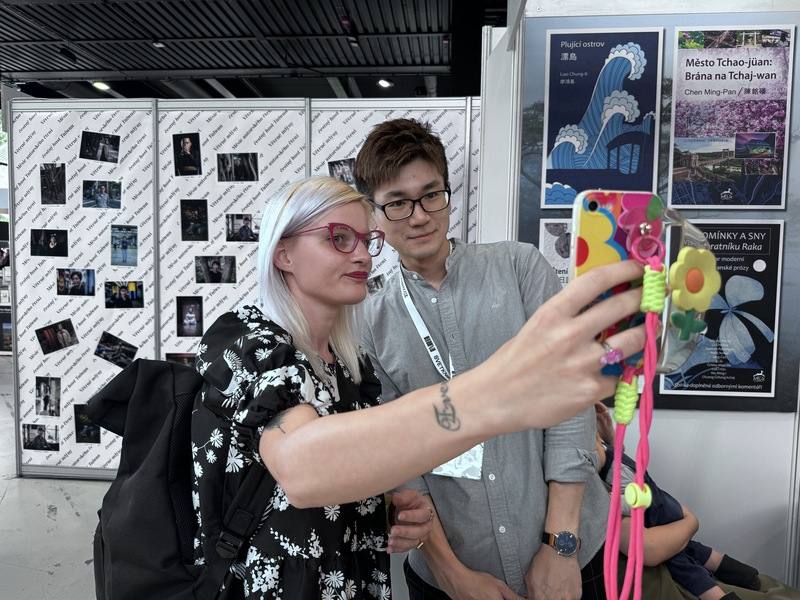 「我的蟻人父親」一書作者謝凱特（右）赴捷克宣傳捷文版譯本。他在布拉格國際書展現場與捷克讀者合照。