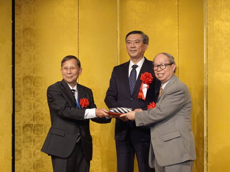 由客家鄉親組成的東京崇正公會1日在東京雅敘園酒店舉辦第54屆懇親大會，並辦理新舊會長交接儀式。在駐日副代表周學佑（中）見證下，會長劉南強（右）交棒給新會長李克順（左）。