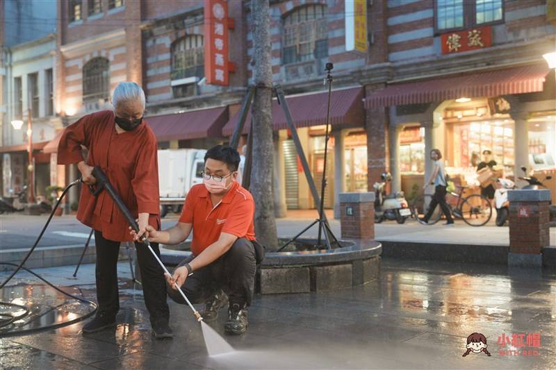 Xiahai City God Temple Manager Chen Wen-wen (left) washes the temple courtyard during a collaborative event with With Red on May 28, 2022. Photo courtesy of With Red June 1, 2024