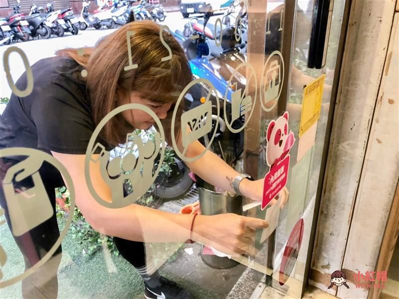 A staff member of a store in Zhongyuan Night Market sticks a “period-friendly space” emblem on the door on Oct. 24, 2023. Photo courtesy of With Red June 1, 2024