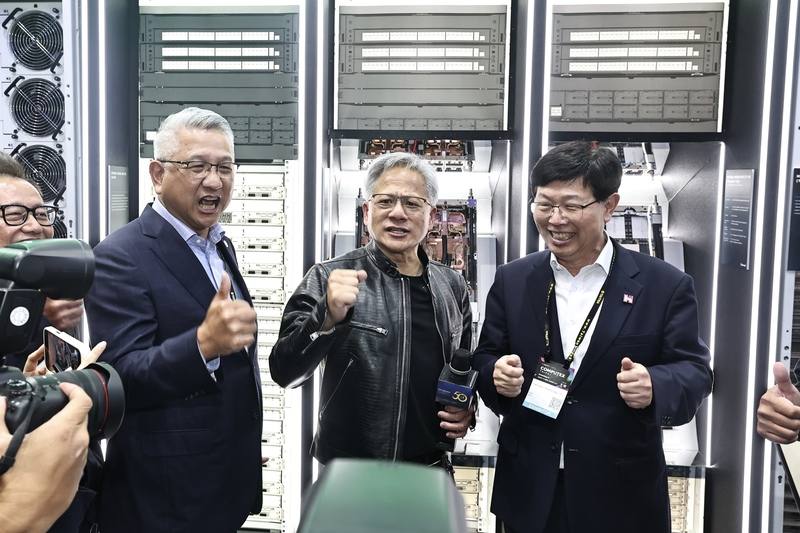 輝達（NVIDIA）執行長黃仁勳（中）4日在2024台北國際電腦展（COMPUTEX 2024）參訪鴻佰攤位，與鴻海董事長劉揚偉（右）互動、喊話。